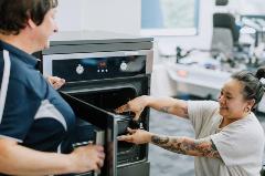 Female customer_adapted oven_OT in abstract Younger female in wheelchair testing adaptive oven with OT in abstract