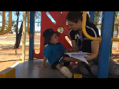 2021_OConnor_AkiraAshley02 Female Indigo schools team member using AAC with a student in the playground