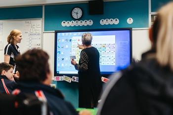 Indigo-31 Classroom with focus on the teacher at the front using interactive whiteboard