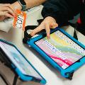 two ipads and hand holding words